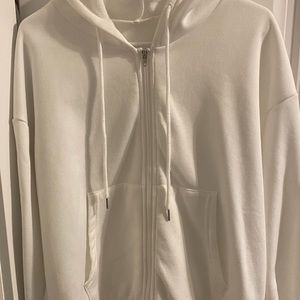 Three zip up hoodies black white and brown